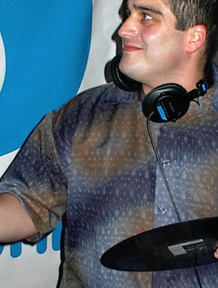 Todd, with a record in his hand, looking at something.